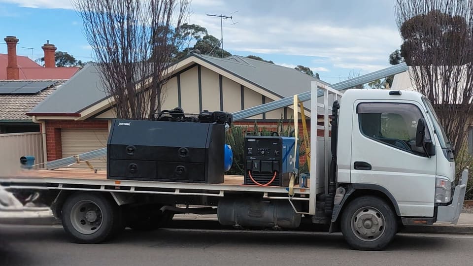 Iron Works Mobile Welding's service truck, fitted out with welding gear, parked on a suburban street
