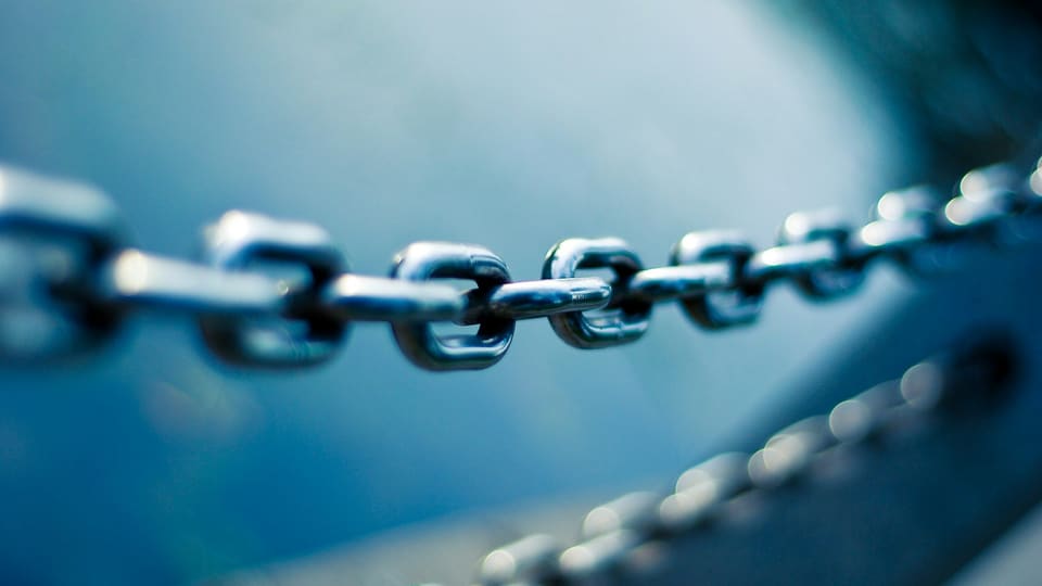 Close-up of a steel chain, its links joined end to end